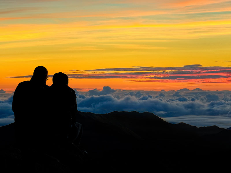A couple watching the sunrise over Haleakala National Park